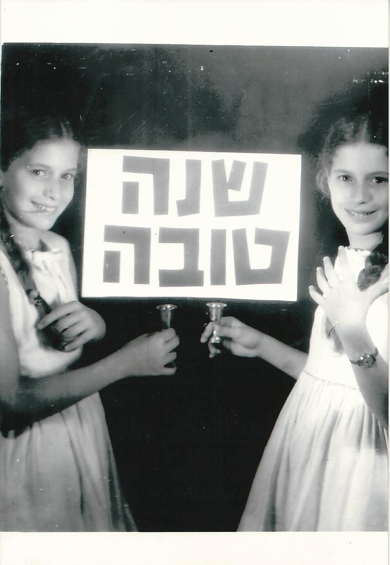 שנה טובה עם צילום של צלילה הילדה מחזיקה בידה שלט שנה טובה וממול אותו הצילום בתמונת מראה